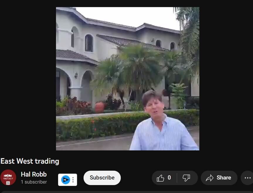 Hal Robb next to his Thailand house from the East West Trading YouTube channel